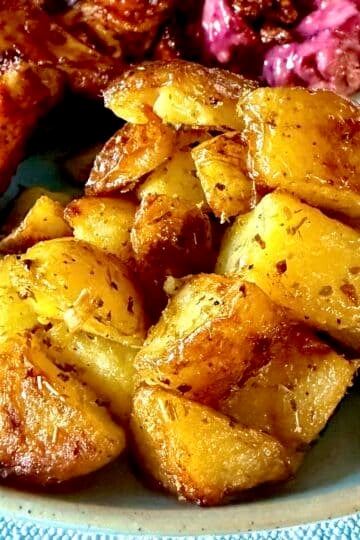 Lemon Oregano Oven Potatoes close up photo on a blue plate for Google featured image.
