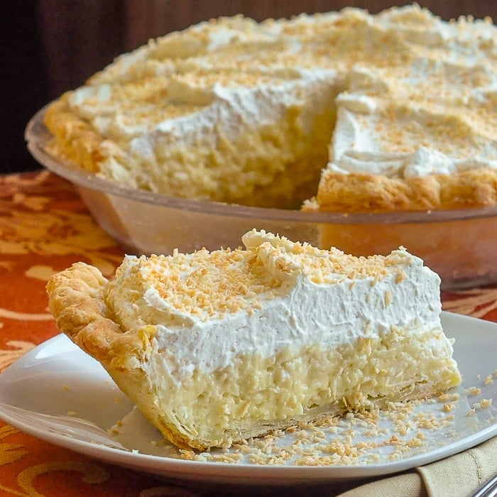 Coconut Cream Pie close up of single slice on a white plate.