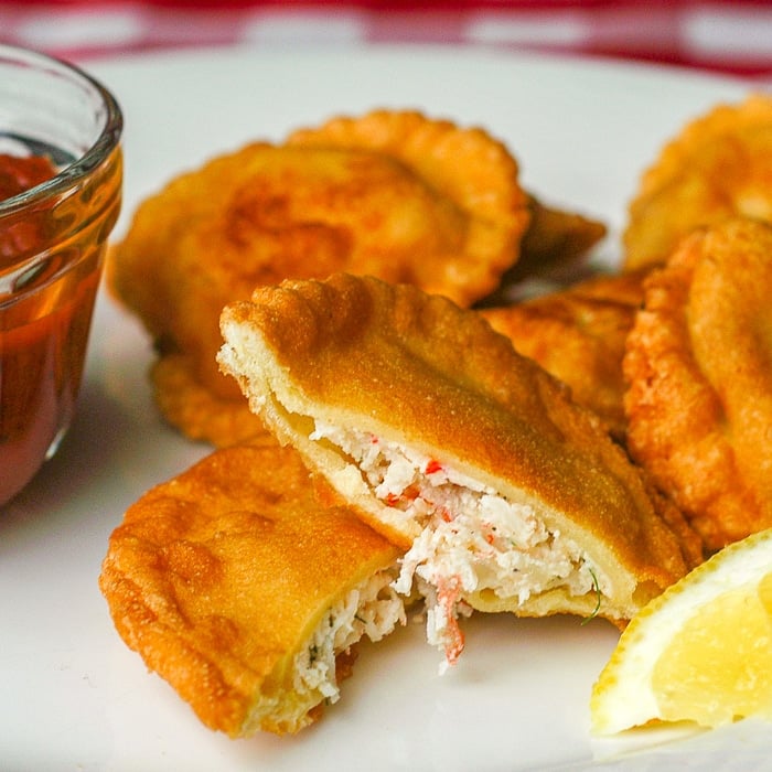 Crab Ricotta Fried Ravioli photo of ravioli in a white plate with lemon and marinara sauce