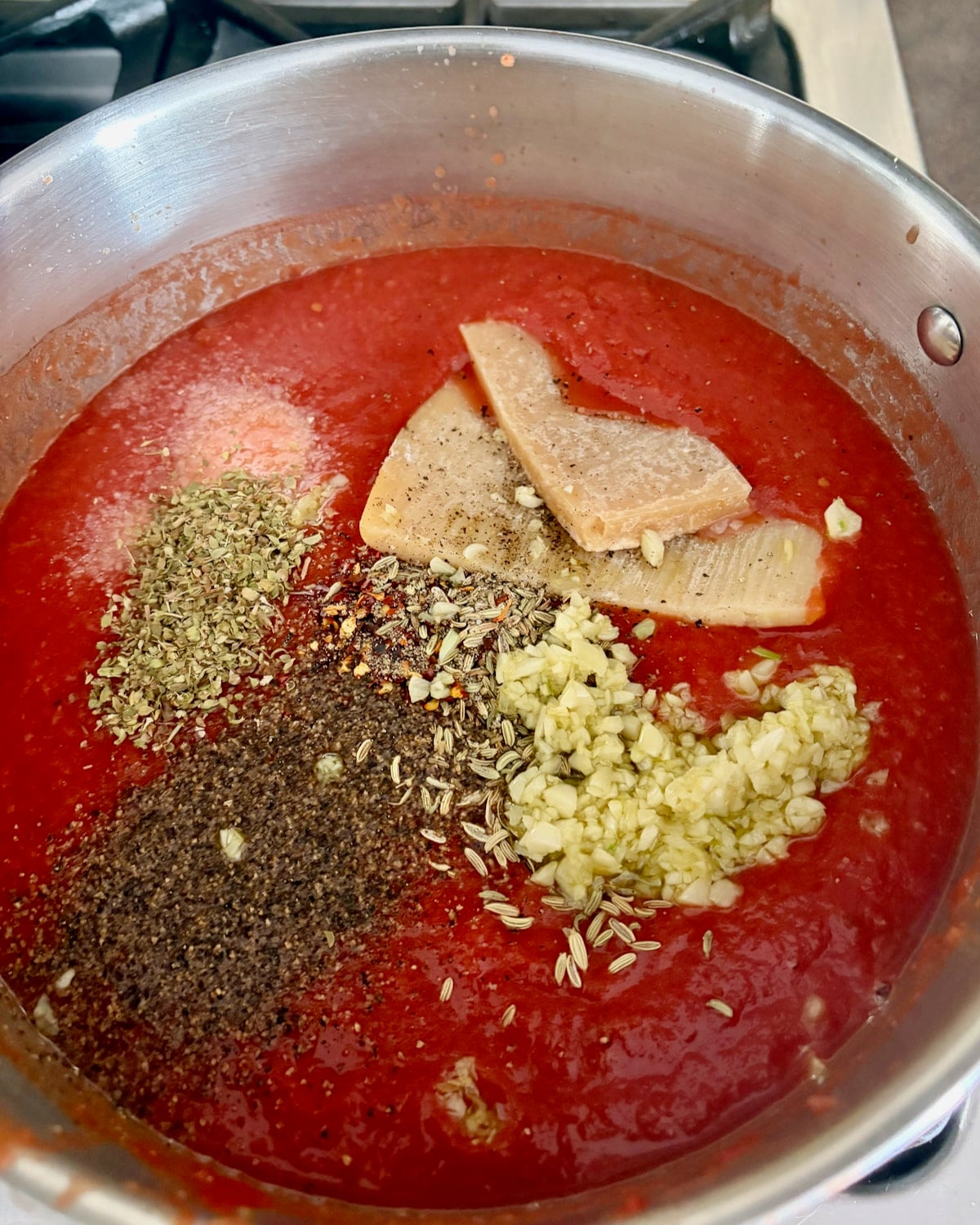Photo of spices and garlic being added to the Roasted Fennel Marinara Sauce.