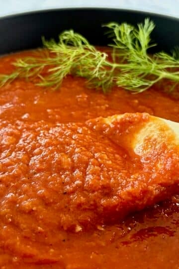 Close up photo of finished sauce being stirred ina dutch oven.