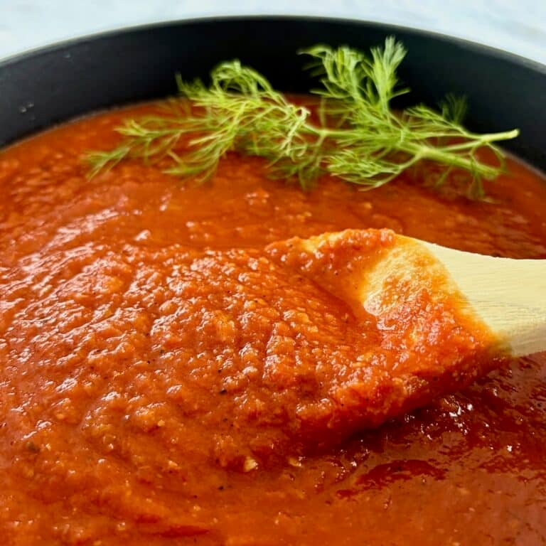 Close up photo of finished sauce being stirred ina dutch oven.