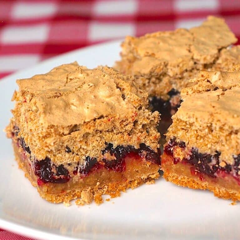 Partridgeberry Coconut Meringue Squares cropped featured image of cut squares on a white plate