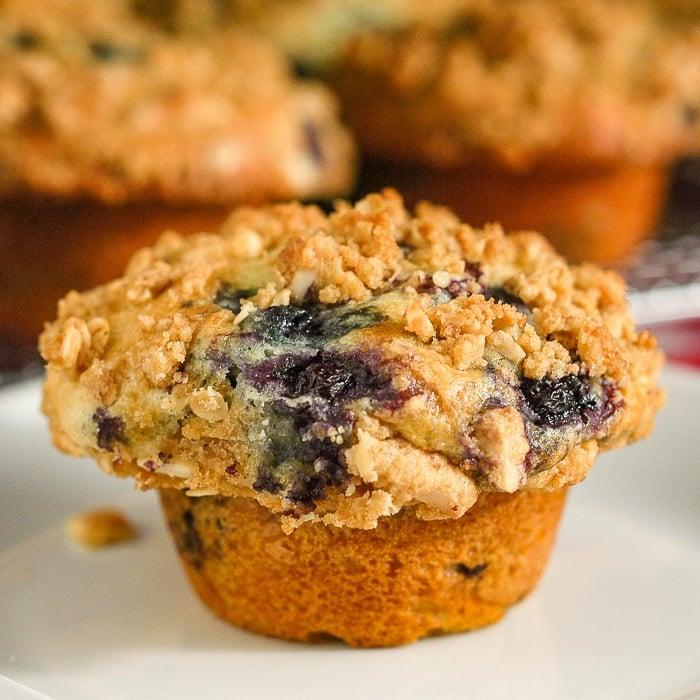 Lemon Blueberry Muffins with oatmeal almond streusel photo of a single muffin on a white plate