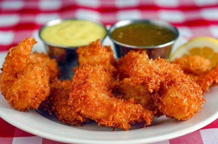 Coconut Shrimp with 2 dipping sauces on a white serving platter.