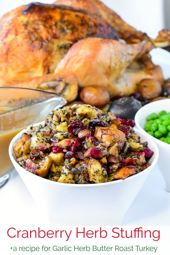 Herb Cranberry Stuffing shown with turkey dinner dishes in the background and title text added for Pinterest