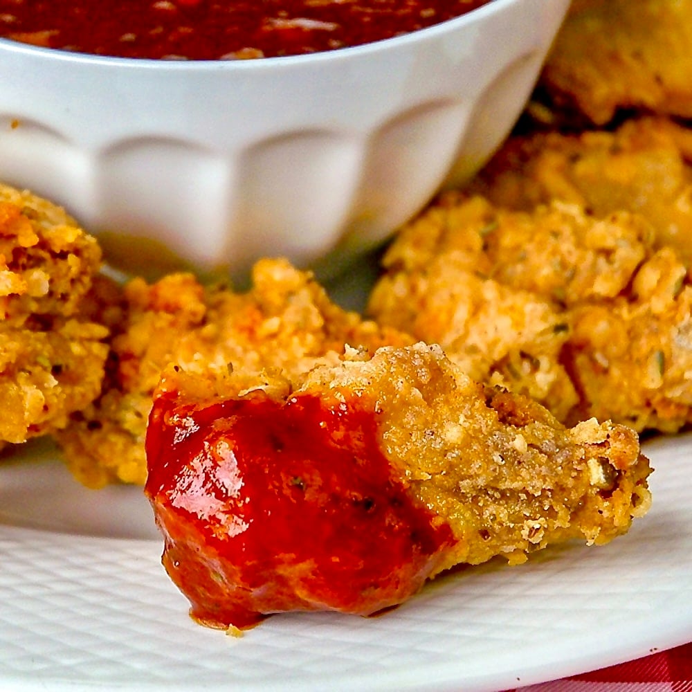 Fried Chicken Wings with Molasses Barbecue Sauce. Photo shows one dipped wing, close up.