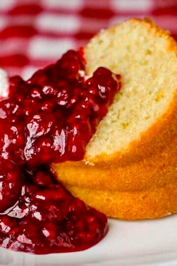 Lime Bundt Cake with raspberry compote photo of one slice on a white plate.