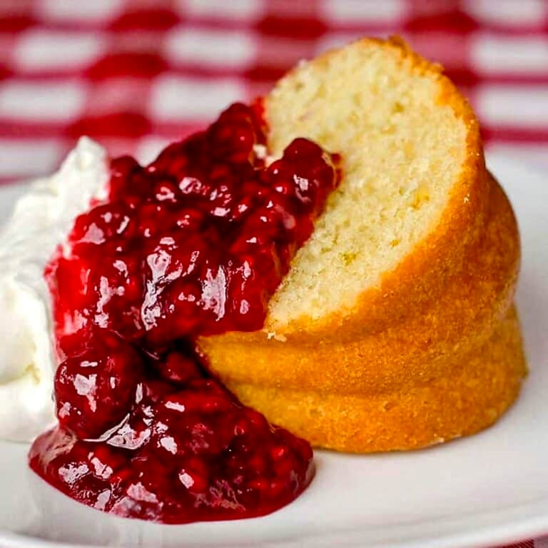 Lime Bundt Cake with raspberry compote photo of one slice on a white plate.