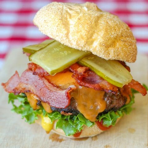 Bacon Sundried Tomato Burgers photo of burger on a wooden cutting board