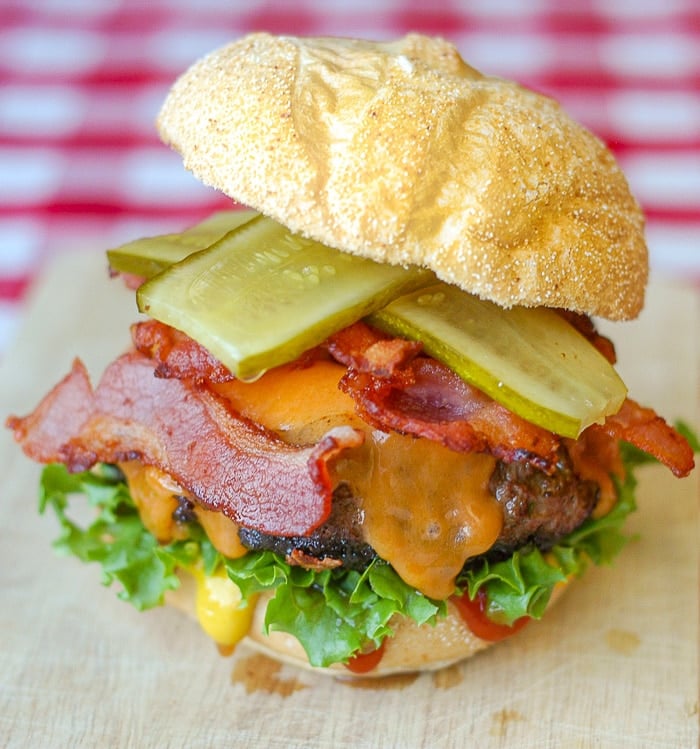 Bacon Sundried Tomato Burgers photo of burger on a wooden cutting board