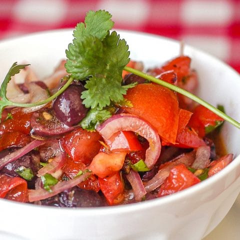 Tomato Olive Salad close up photo pf salad in a white bowl