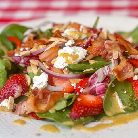 Strawberry Spinach Salad close up photo of finished salad on a white plate