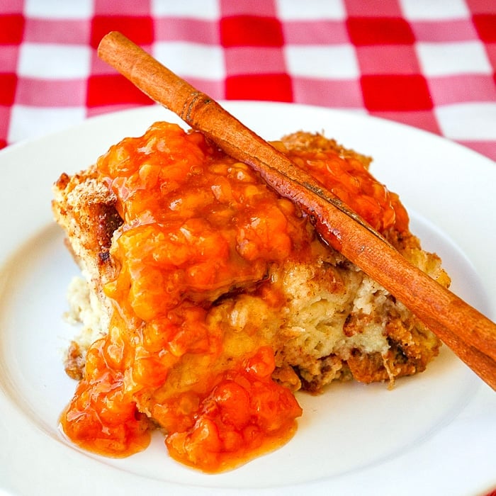 Bakeapple Cinnamon Bread Pudding shown on a white plate with connamon stick