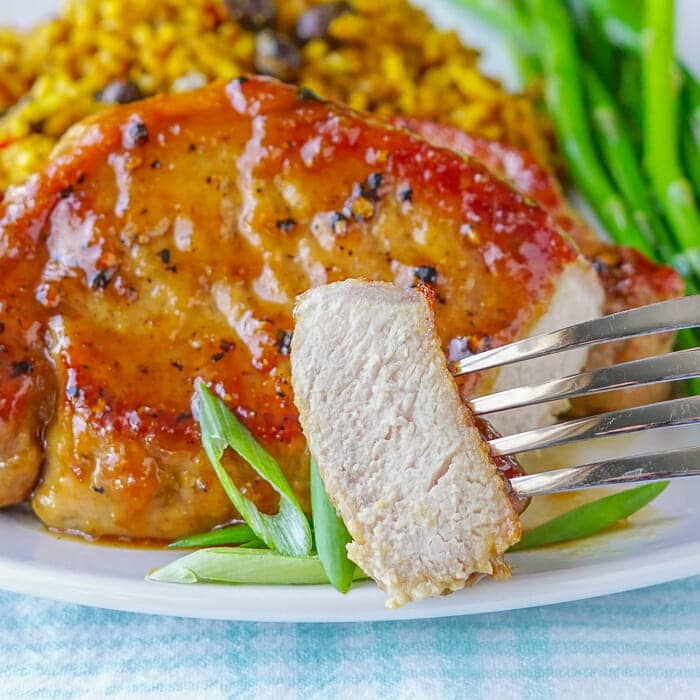 Honey Ginger Dijon Glazed Pork Chops photo od cut pork chop showing fully cooked inside.