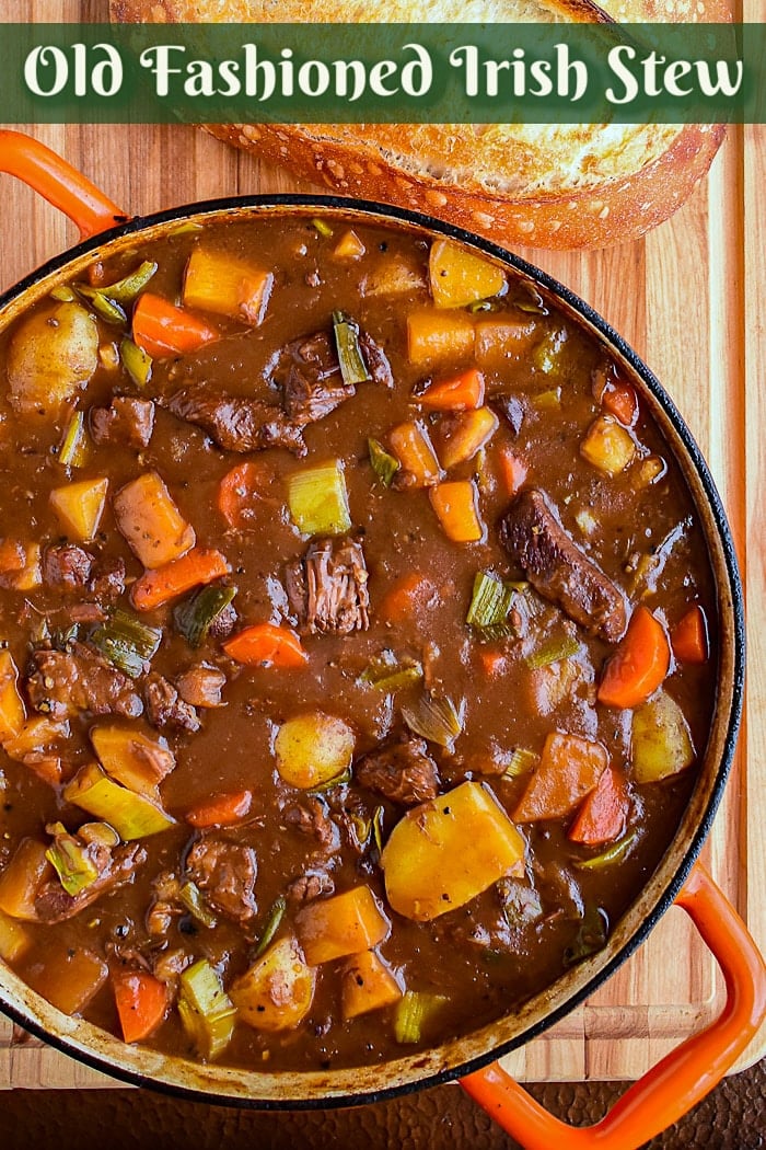 Irish Stew in an orange dutch oven with title text added for Pinterest