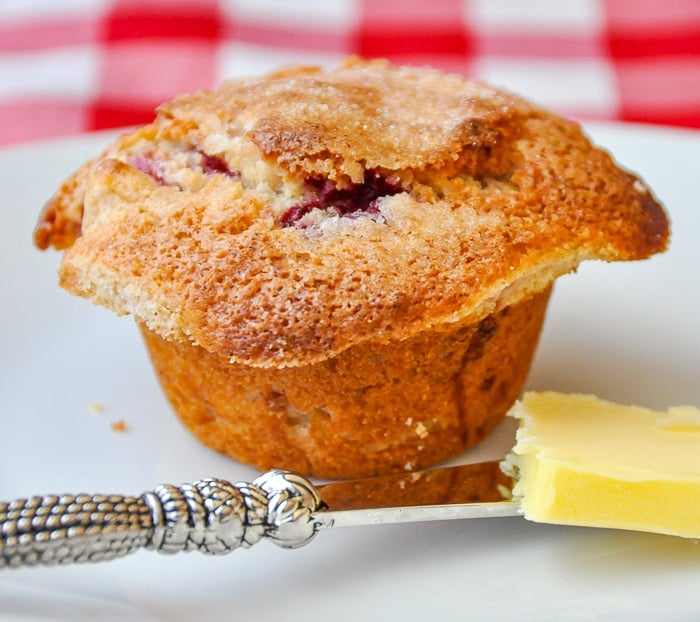 Apple Raspberry Muffins photo of one muffin on a white plate with butter knife