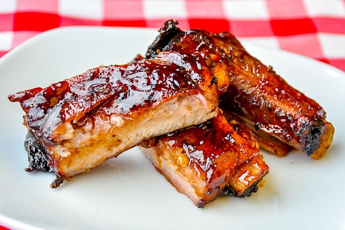 Black Bean Ginger Glazed Ribs on a white plate with red checkered tablecloth background