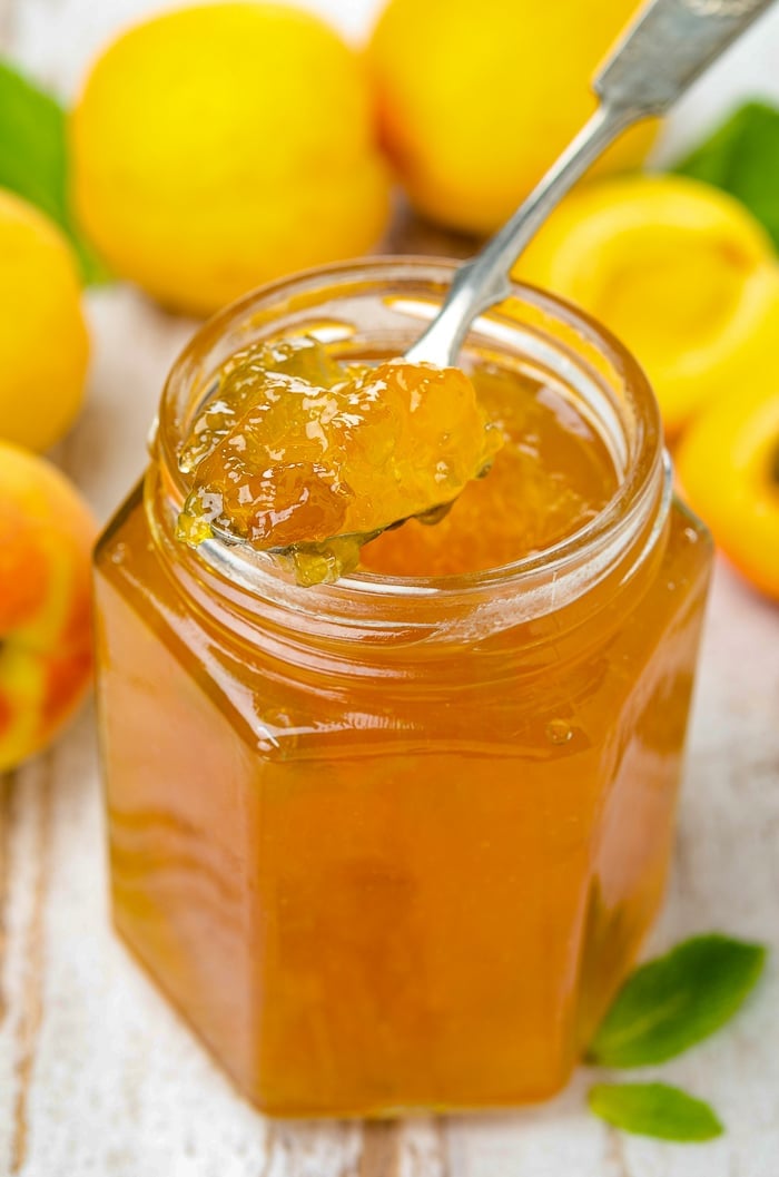 Apricot Jam in a clear glass jar.