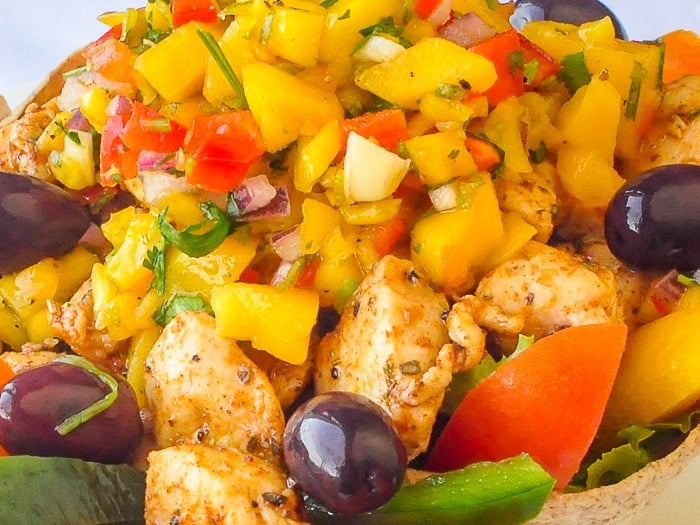 Low Fat Chicken Taco Salad with Mango Salsa close up photo od salad in baked taco bowl