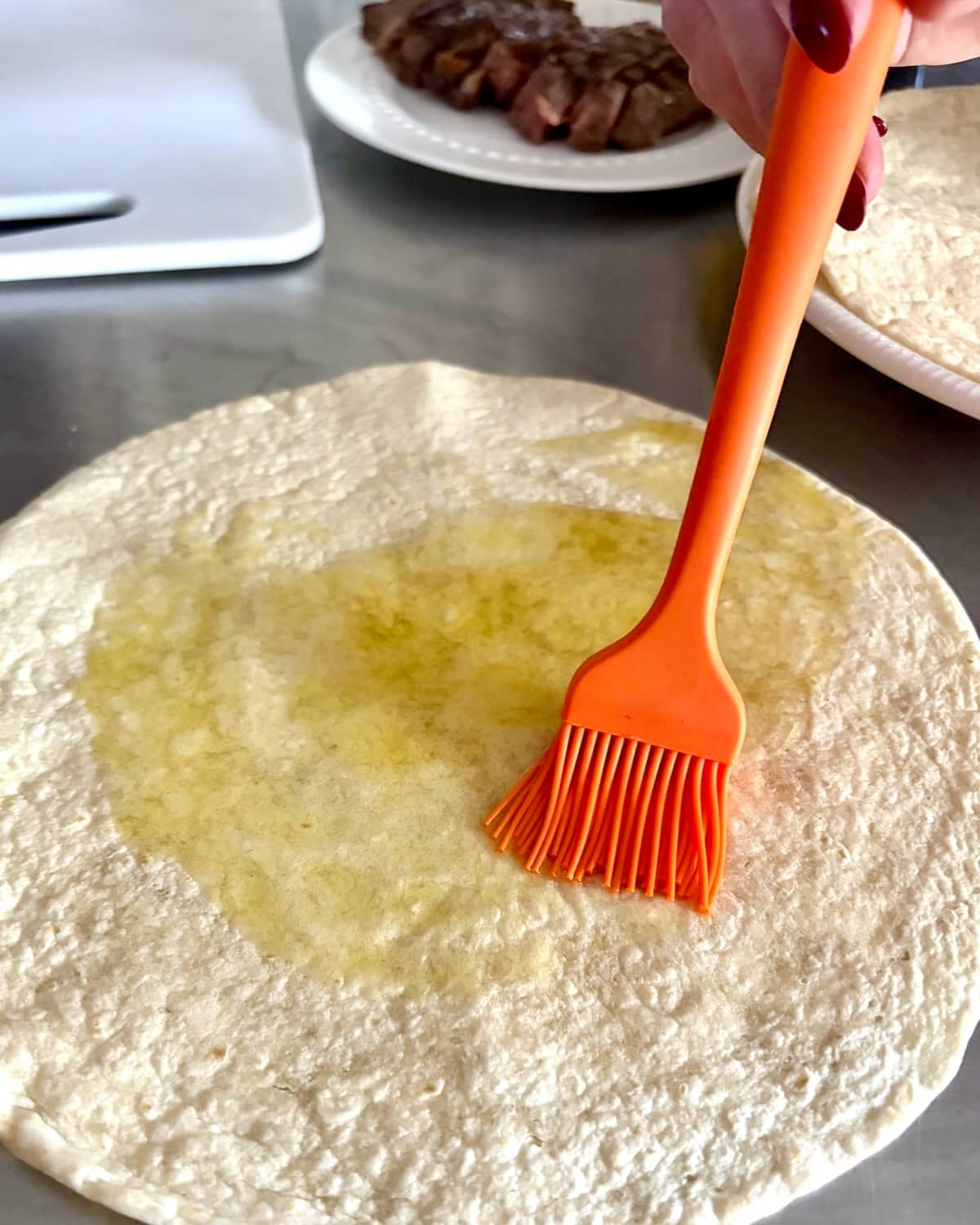 Brushing oil on tortillas