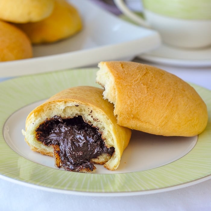 Petit Pains au Chocolat close up photo of pastry broken open showing chocolate centre