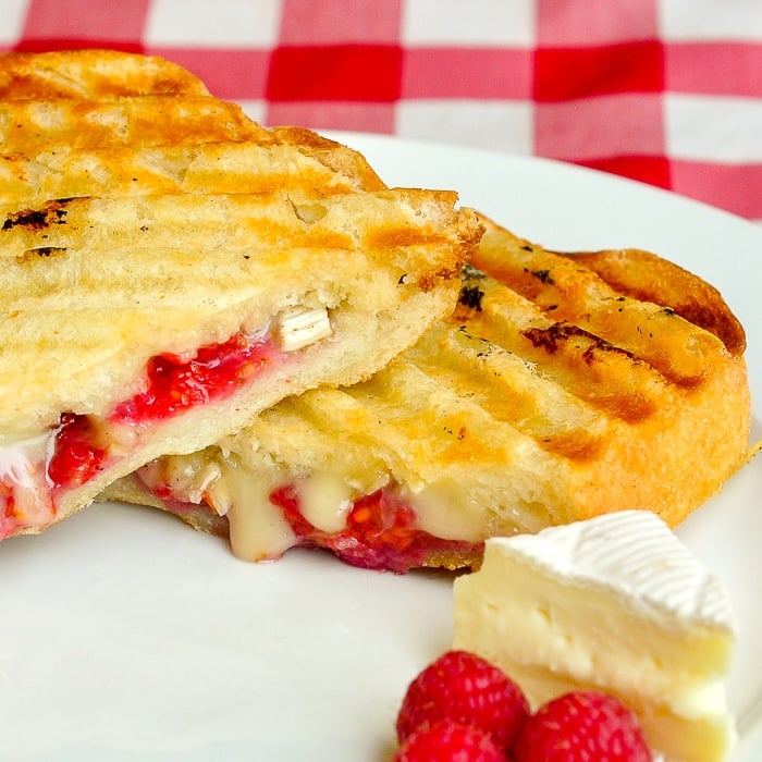 Raspberry Brie Panini close up pohoto showing melting brie cheese and raspberries in the sandwich
