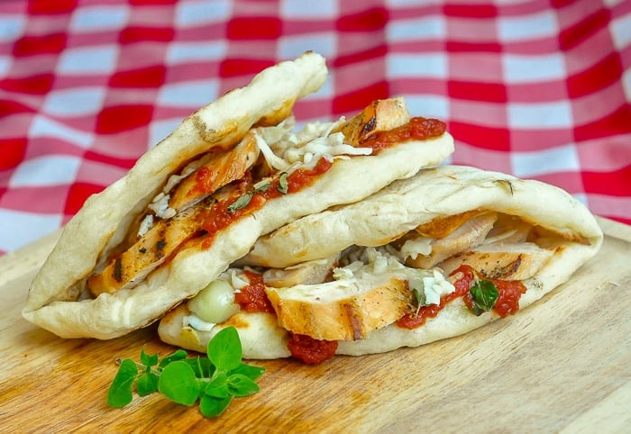 Grilled Chicken Parmesan Flatbread Sandwiches wide shot photo on wooden cutting board