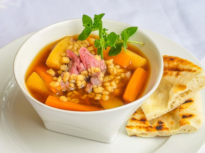 Steak and Barley Soup shown with flatbread on the side