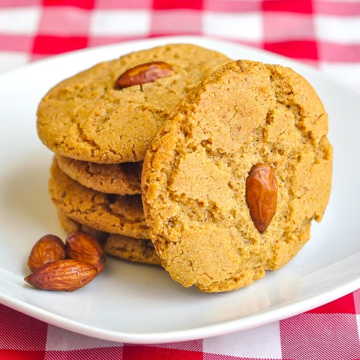 Almond Butter Cookies photo of cookies stacked on a white plate with 3 whole almonds