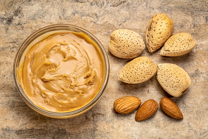 Stock photo of Almond butter and whole almonds 