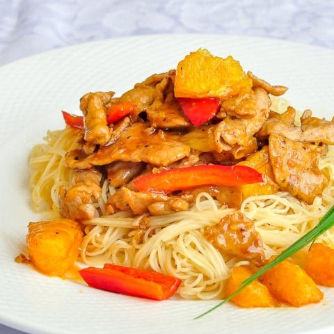 Spicy Honey Orange Sliced Pork close up photo of single serving on white plate