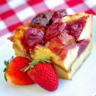 Strawberries & Cream Bread Pudding close up photo of a single serving on a white plate