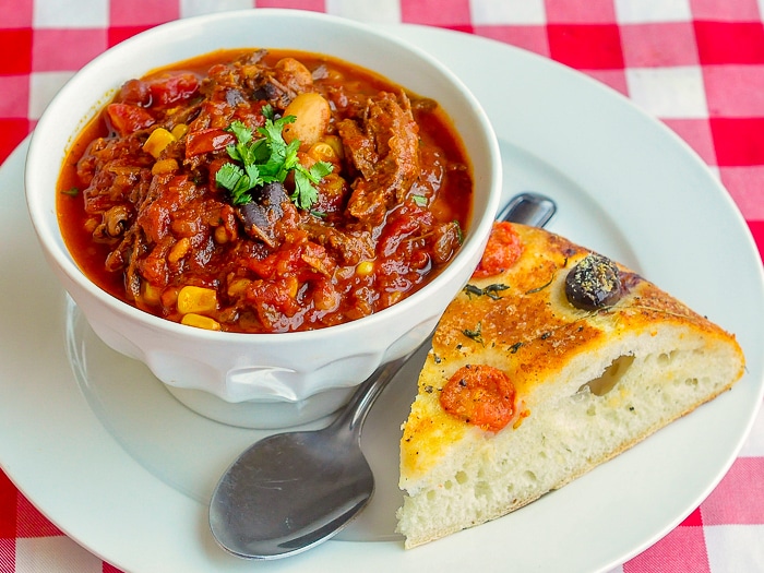Braised Beef Oven Chili wide shot plated with focaccia bread 