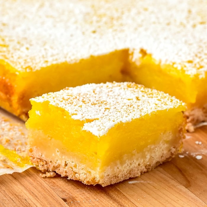 Close up photo of a single cookie bar on a wooden cutting board