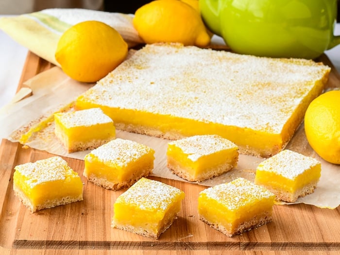 Lemon bars shown with fresh lemons