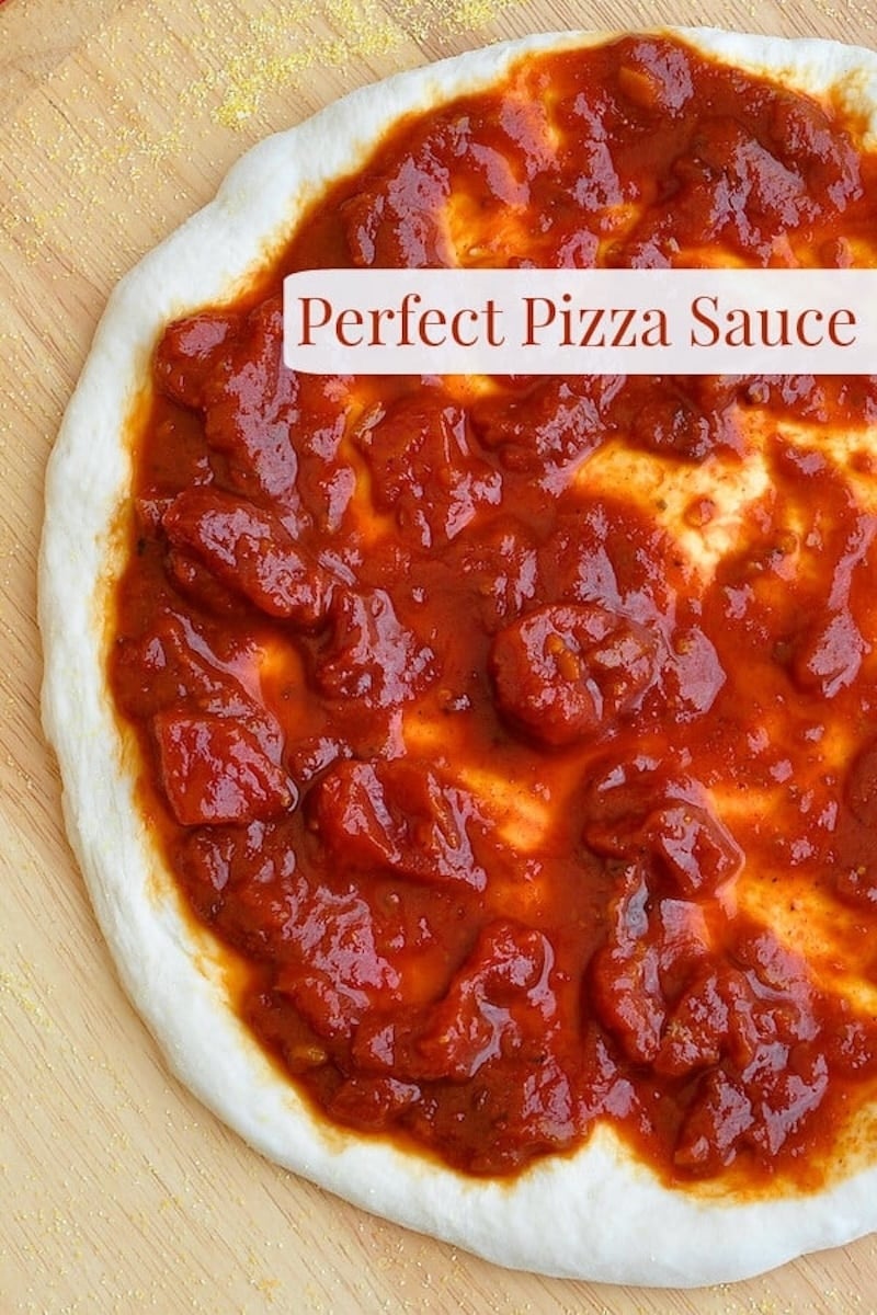 Perfect Pizza Sauce photo of sauce in stretched pizza dough with title text added for Pinterest.