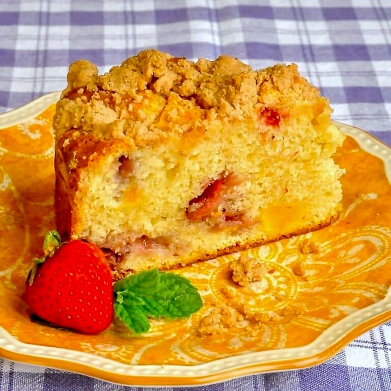 Strawberry Mango Crumb Cake close up photo of single slice on a yellow patterned plate