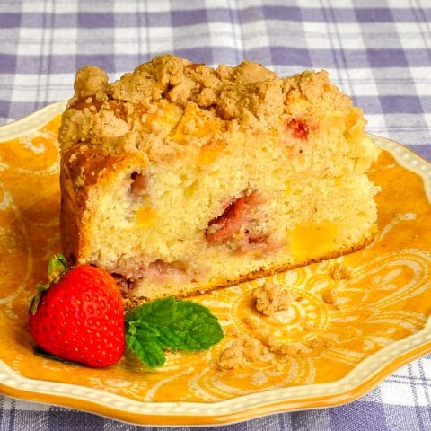 Strawberry Mango Crumb Cake close up photo of single slice on a yellow patterned plate