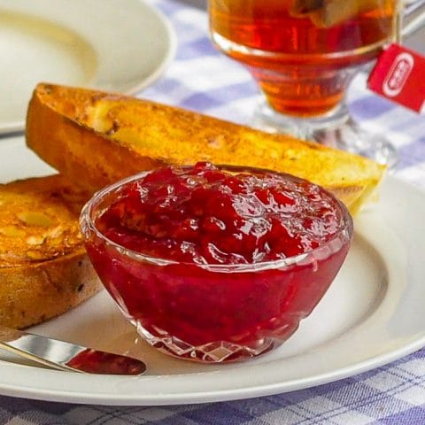 Cherry Apple Jam in small glass dish with toast in background