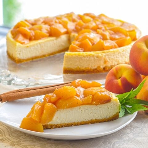 Peaches and Cream Flan photo of a single slice on a white plate with peaches on the side