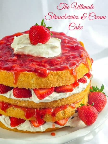 The Ultimate Strawberries and Cream Cake photo of cake on a white pedestal stand with title text added for Pinterest