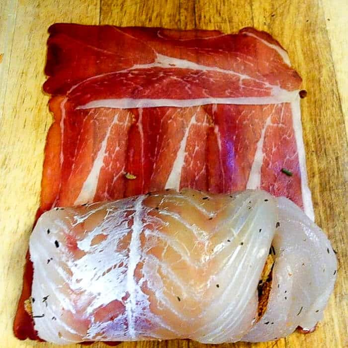 How to roll the stuffed cod in prosciutto.