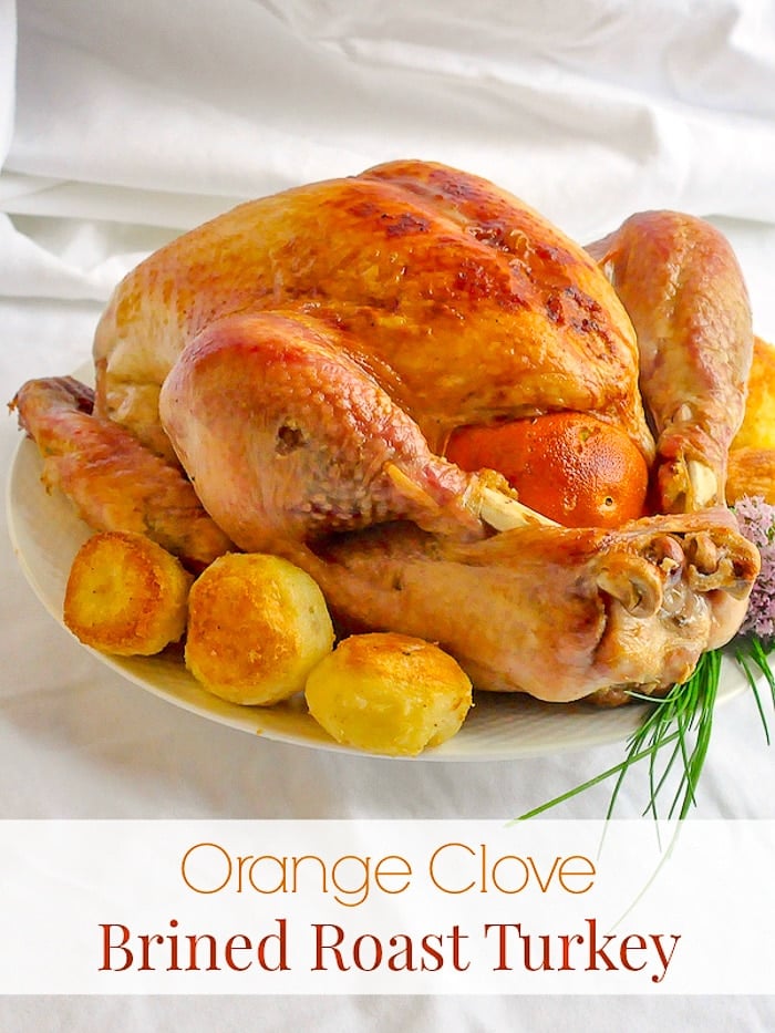 Orange Clove Brined Roast Turkey photo of completely cooked turkey with title text added for Pinterest