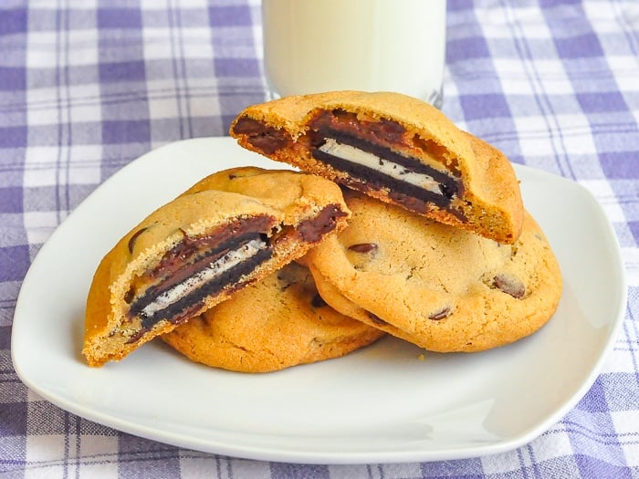 Oreo Stuffed Chocolate Chip Cookies on a white plate with glass of milk