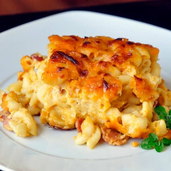 Four Cheese Bacon Mac and Cheese. photo of one serving on a white plate.