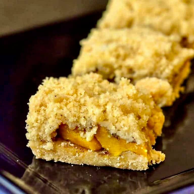 Mango Five Spice Crumble Bars close up photo in a black plate for Google featured image.