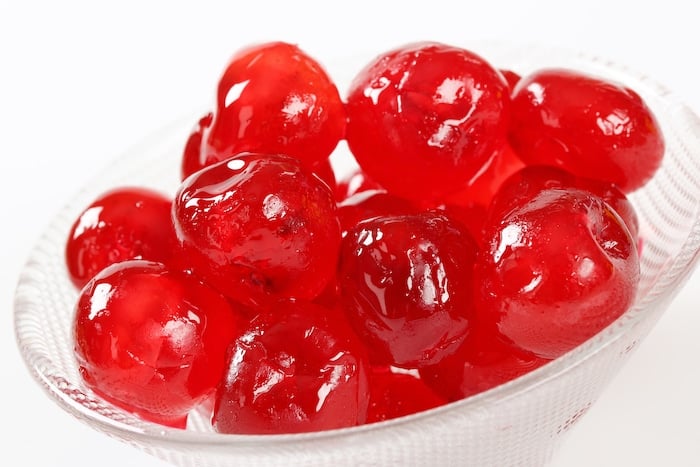 Red Glacé Cherries for Cherry Vanilla Cheesecake Bars, pictured in a glass bowl.