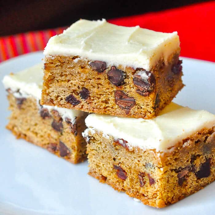 Chocolate Chip Cherry Bars close up image of stacked cookie bars on a white plate.