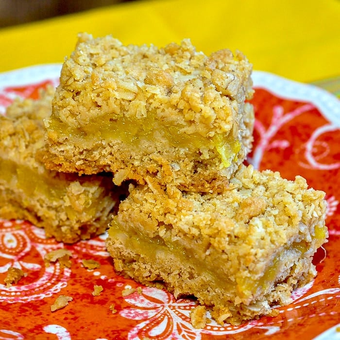 Pineapple Oat Bars photo of 3 cookie squares on an orange plate.